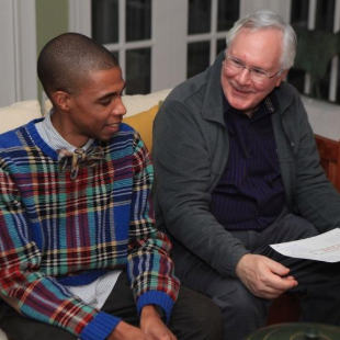 Richard Curley sitting on the couch with another AGHL student